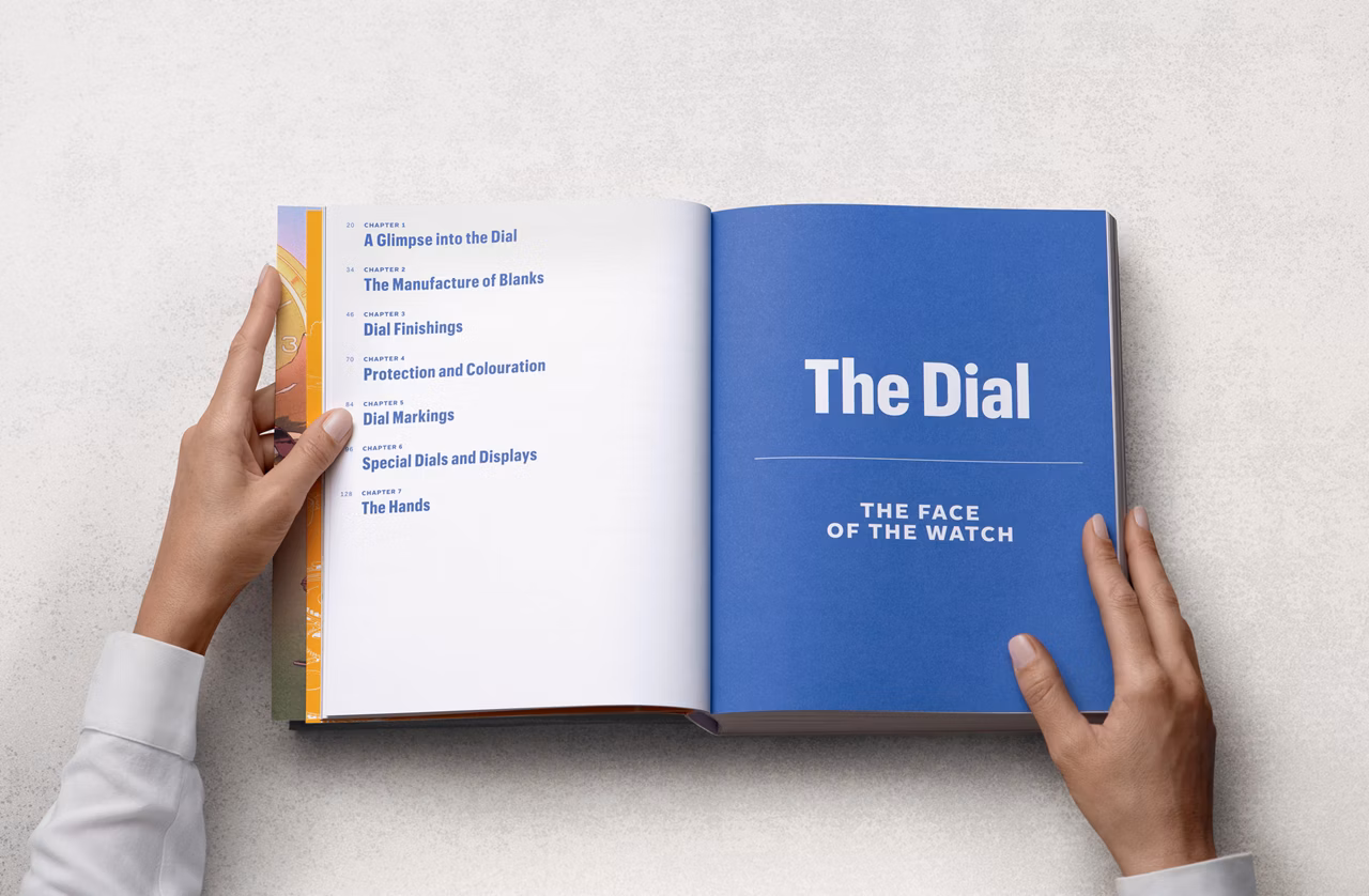 Nahaufnahme der Hände einer Frau, die in einem gebundenen Buch das Kapitel „Das Zifferblatt“ aufschlägt.