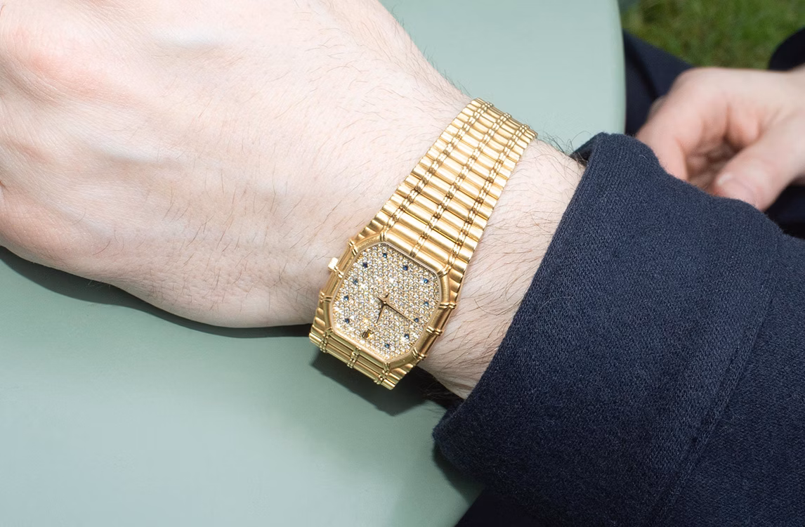 Audemars Piguet Bamboo watch: wrist wearing a gold watch with a pave diamond and sapphire dial.