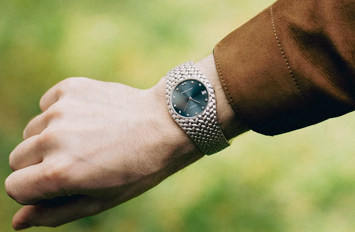 Audemars Piguet Cobra watch: wrist wearing a silver textured watch with a green dial, brown suede sleeve.