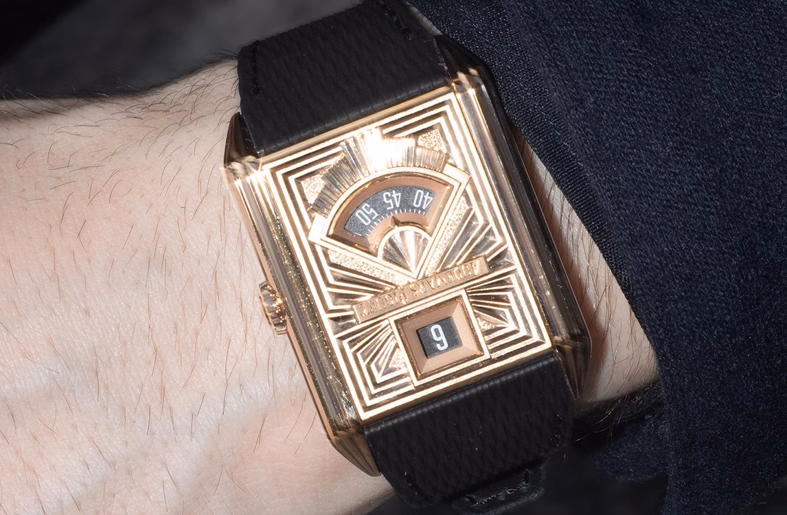 Audemars Piguet Neo Frame prototype: close-up of a rose gold Art Deco style watch with a retrograde minute display on a black strap.