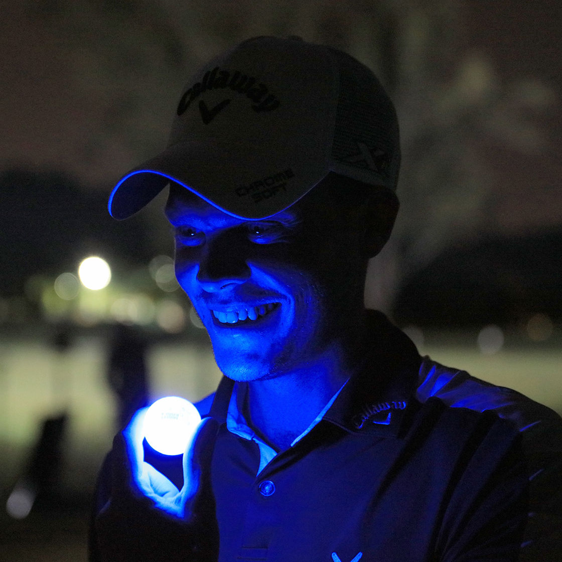 Nachtaufnahme von Danny Willett mit einem fluoreszierenden Golfball in der Hand