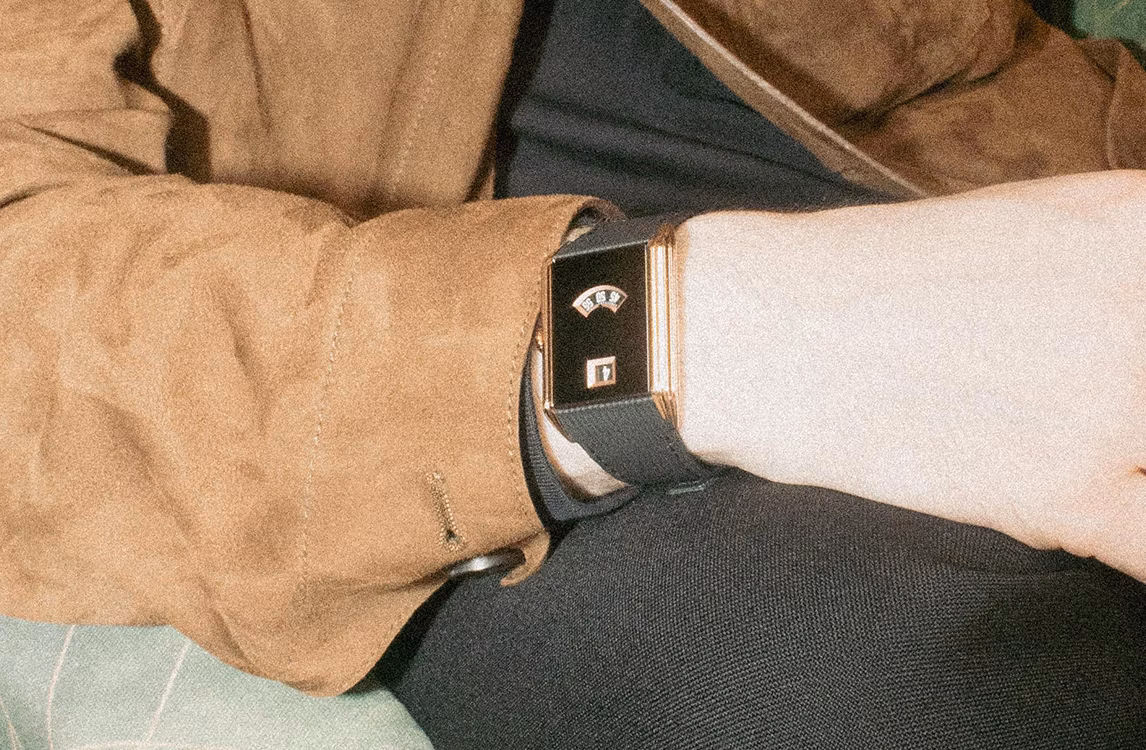 Audemars Piguet Neo Frame watch: wrist wearing a rectangular Art Deco watch with a black dial, brown suede jacket sleeve.