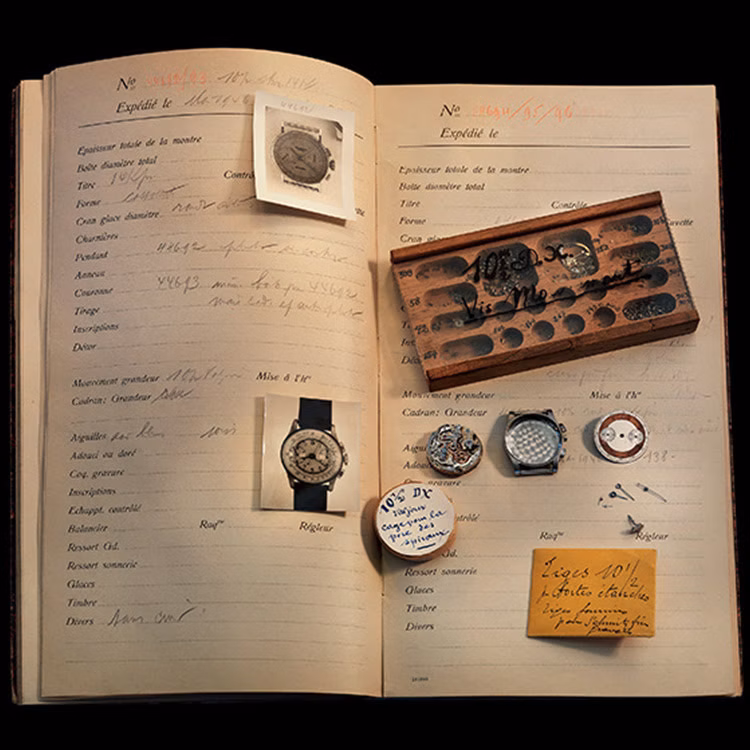 Register book and parts of historical watches preserved in wooden boxes.