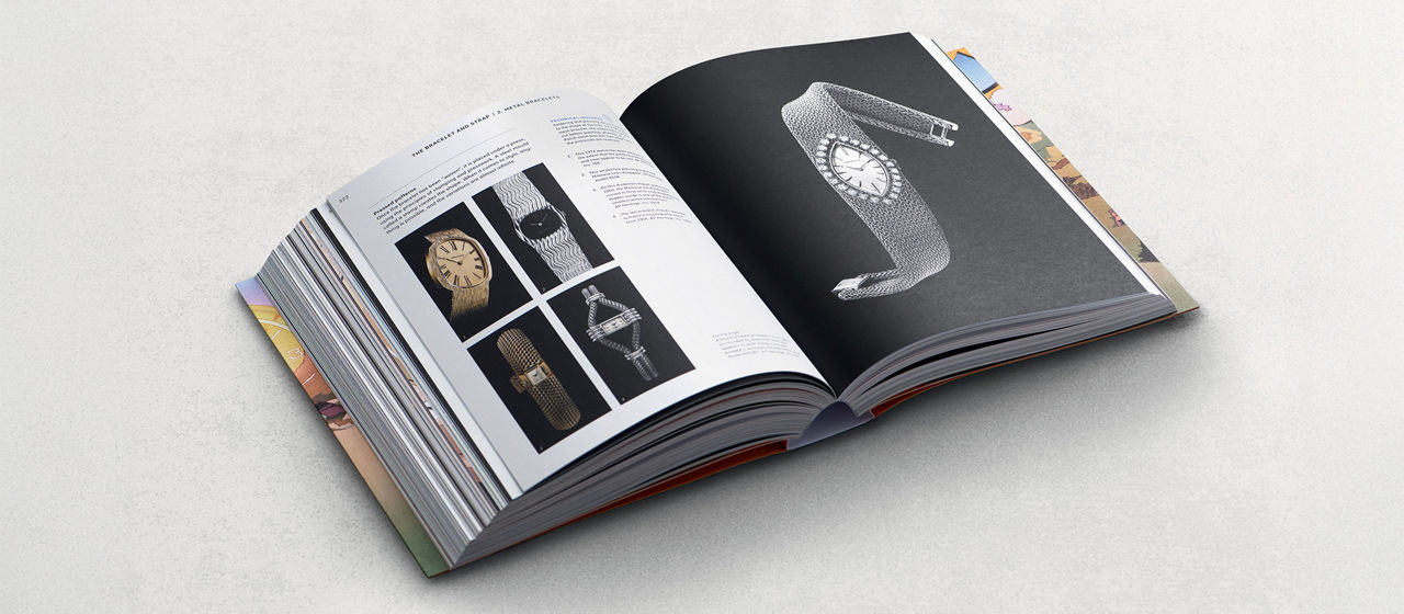 An open hardcover book displaying printed pages with detailed photographs of elegant jewellery watches.