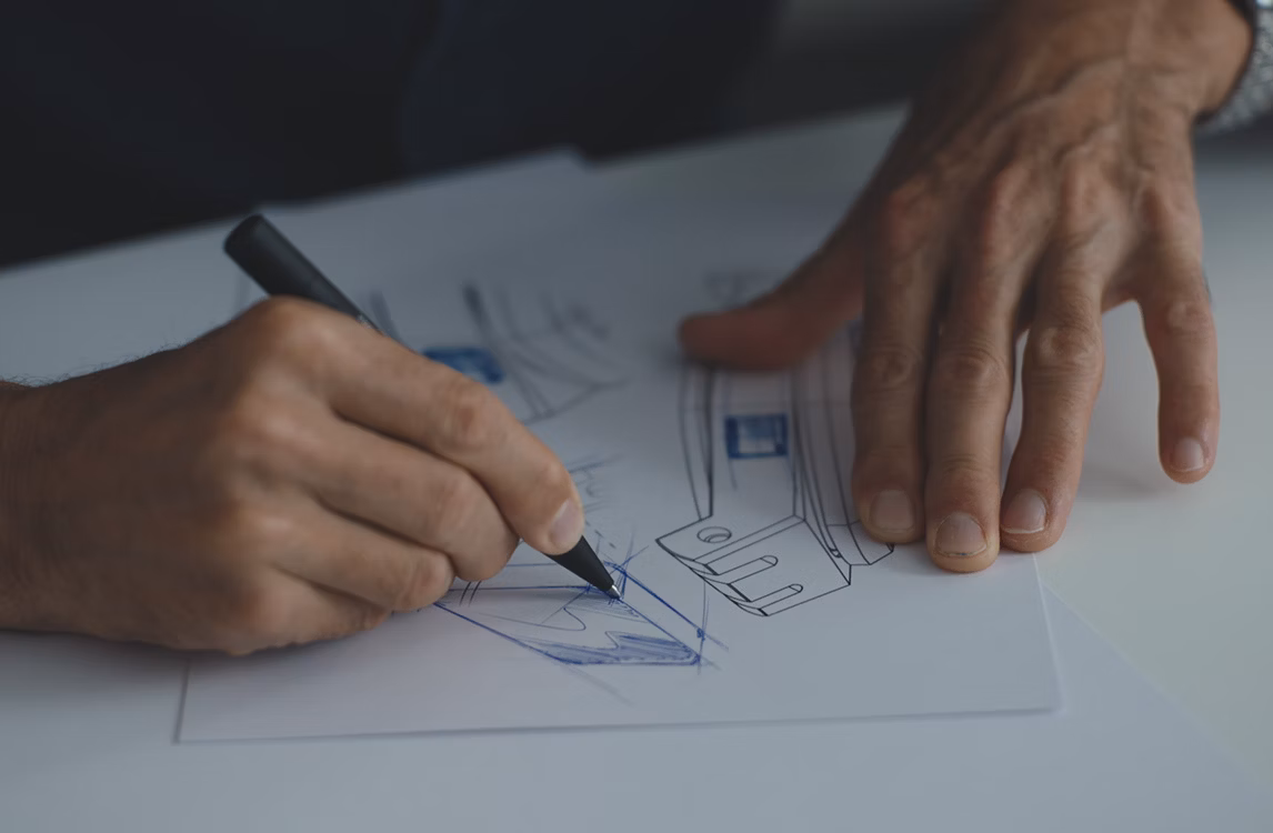 設計過程中，雙手在紙上勾勒腕錶草圖。