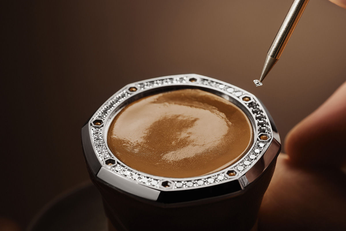 Hand-setting of a diamond onto an octagonal gold bezel using a wax pickup tool.