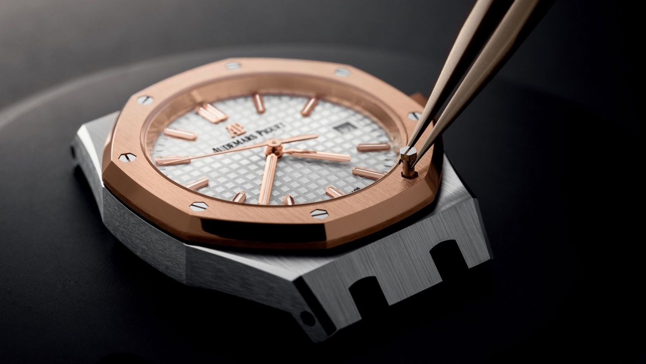 Eine Uhr wird von einem Uhrmacher montiert.