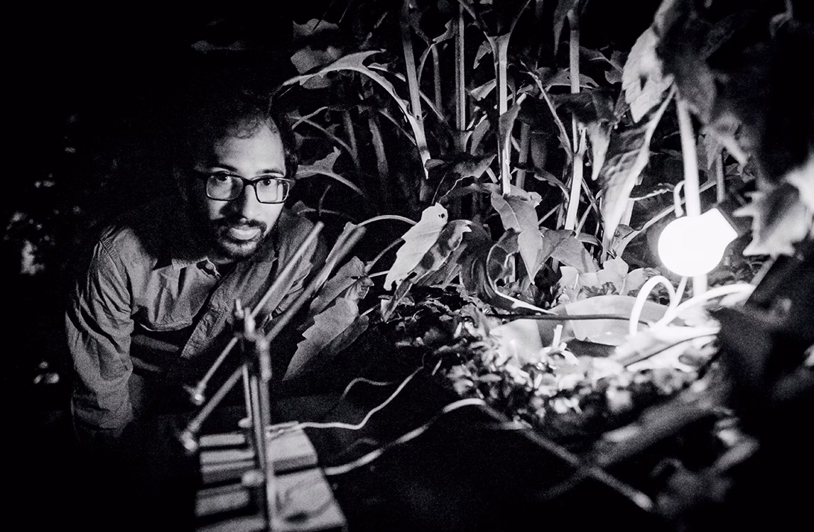 L'artista Robin Mei accanto alla sua installazione artistica Synchronicity costituita da vegetazione