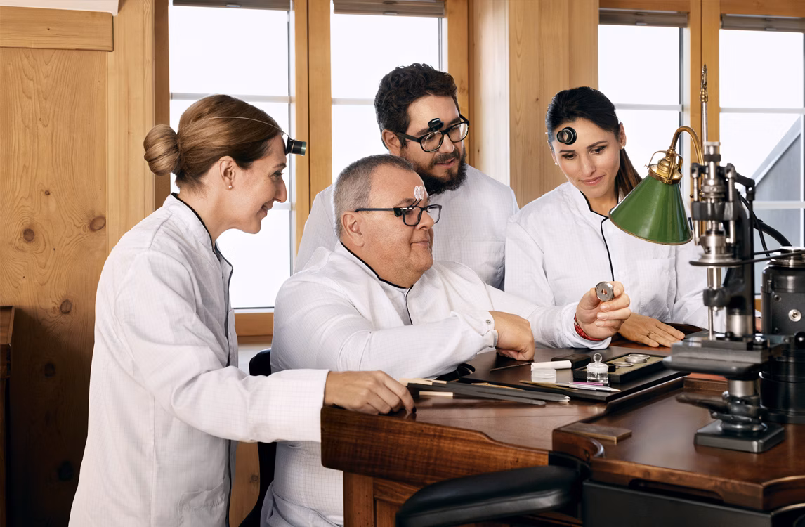 時計師の服を着て部品を見る人々