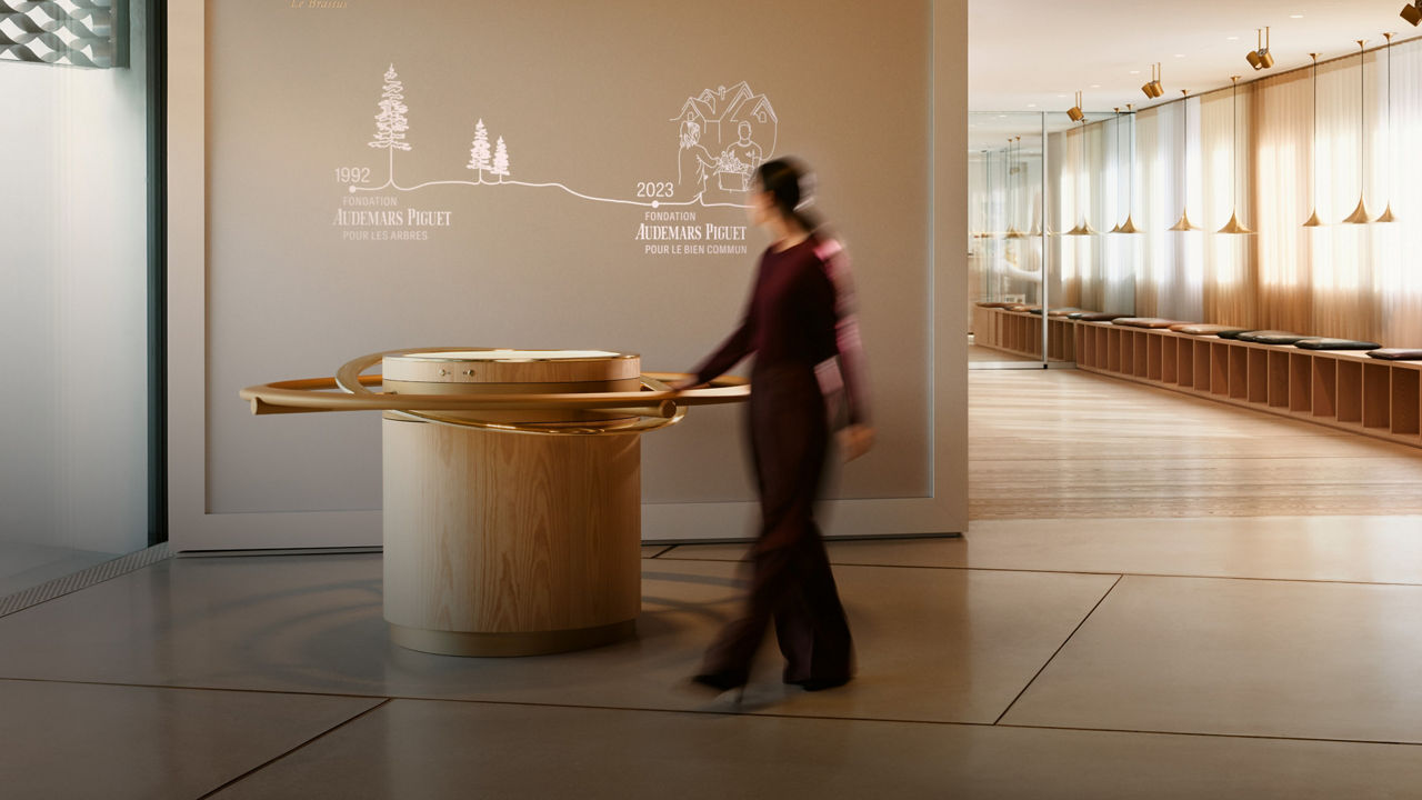 Visitor inside the Musée Atelier Audemars Piguet walking past information regarding Audemars Piguet Foundations.