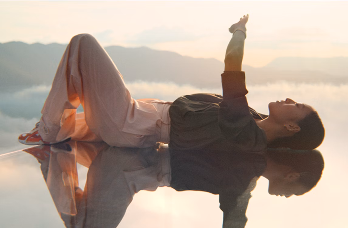 Рекламная кампания Audemars Piguet «Выйти за рамки»: женщина лежит на воображаемом канате в небе.