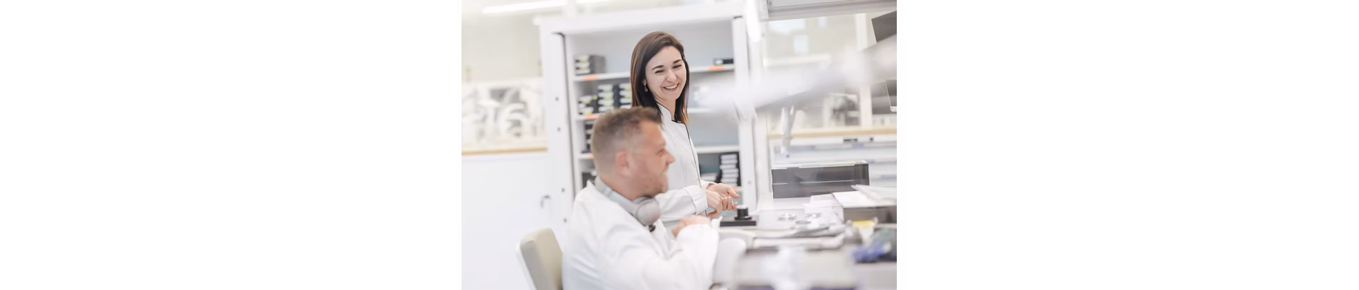 Two colleagues in a workshop having a casual conversation.