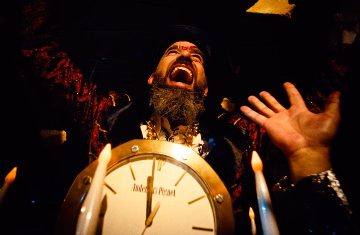 ケーキから出てきて観衆に拍手される男性