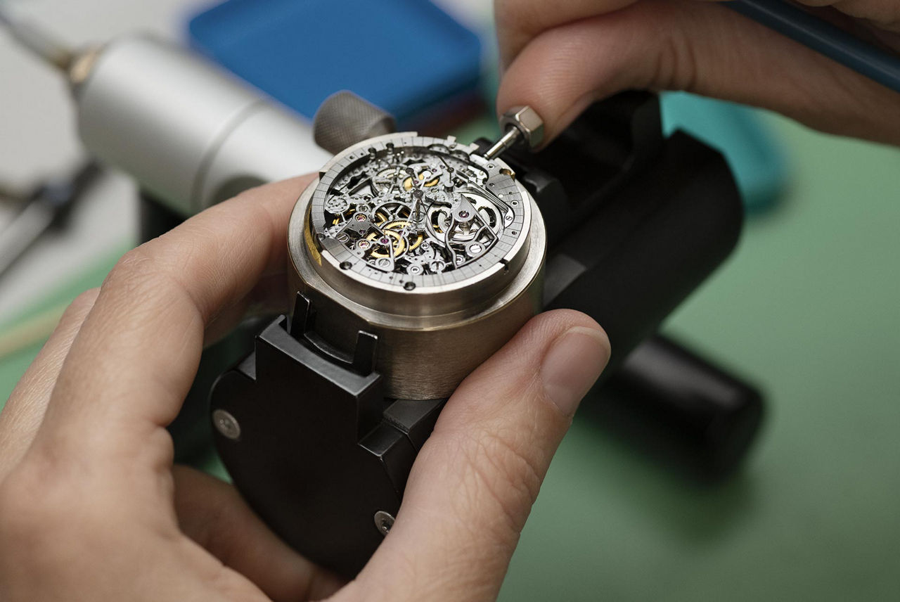 Relojero ensamblando un reloj.