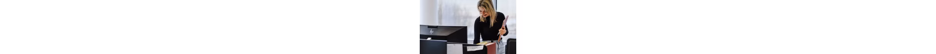 A smiling employee with a folder in her hand.