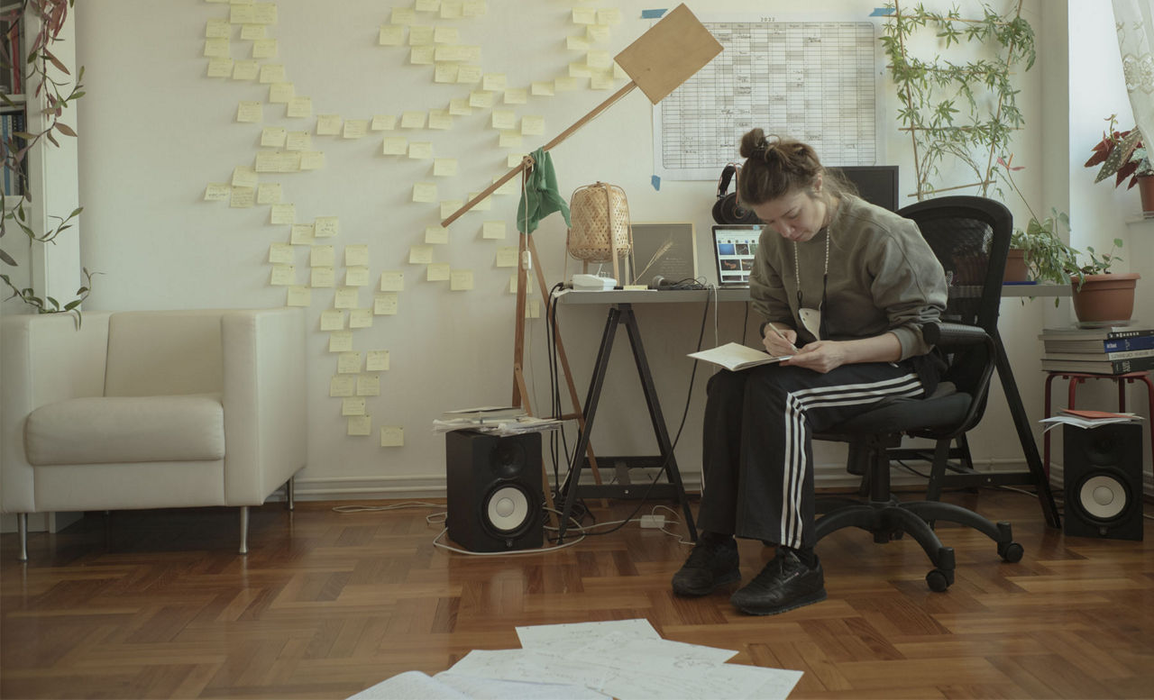 Alexandra Pirici che scrive su un taccuino alla sua scrivania