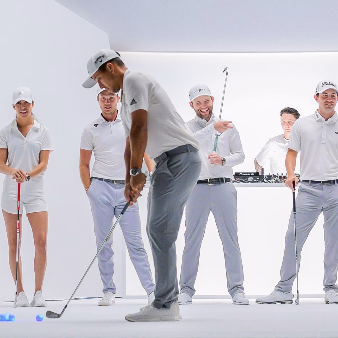 Golfers playing indoor with a DJ in the background