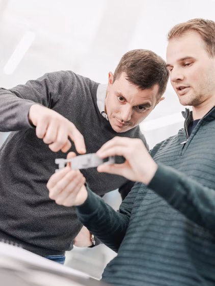 Two colleagues studying a watch strap prototype.