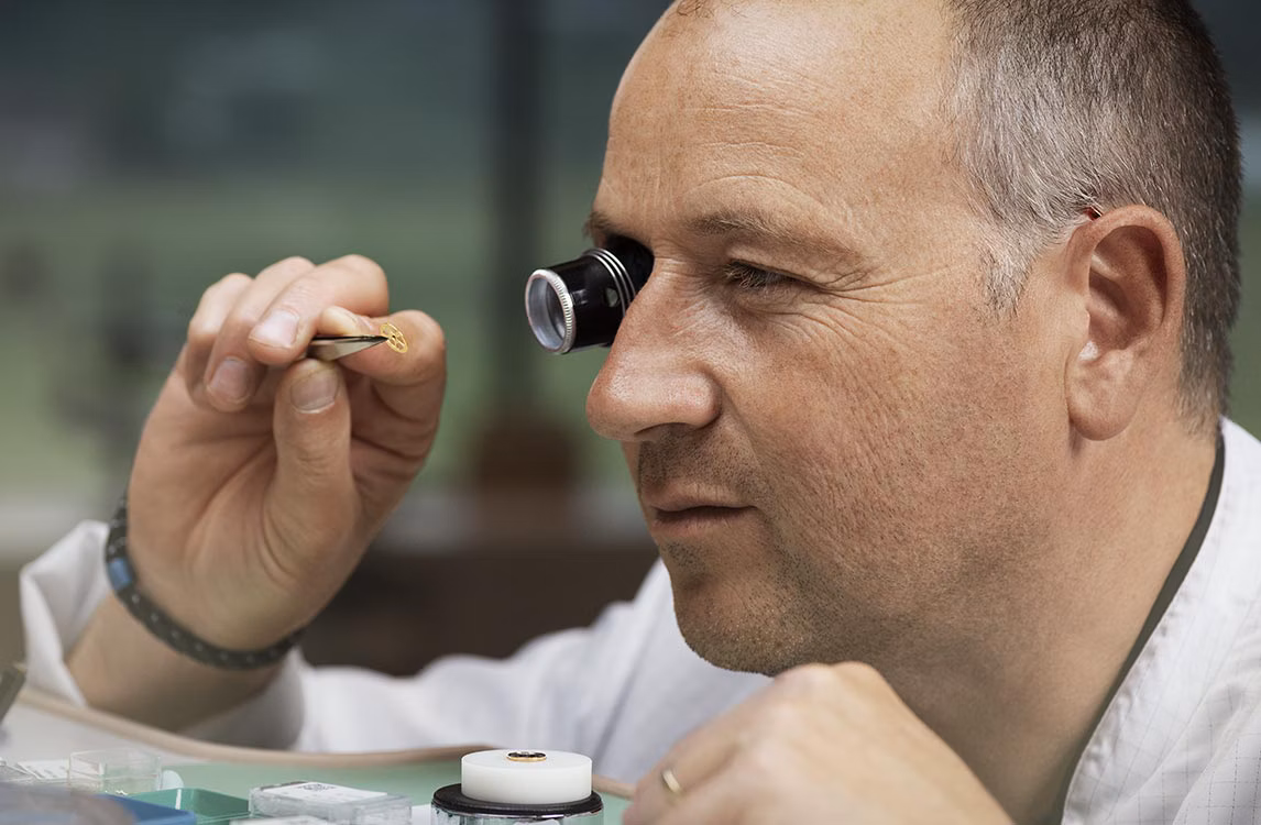 Relojero trabajando en un taller.